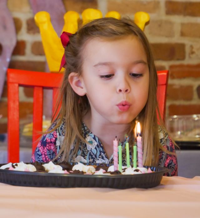 A child blowing out birthday candles at Audubon Zoo